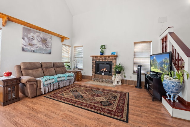 7824 Snowberry St NW, Albuquerque, NM 87120 - living area featuring high vaulted ceiling, a fireplace, wood finished floors, healthy amount of natural light, and stairway