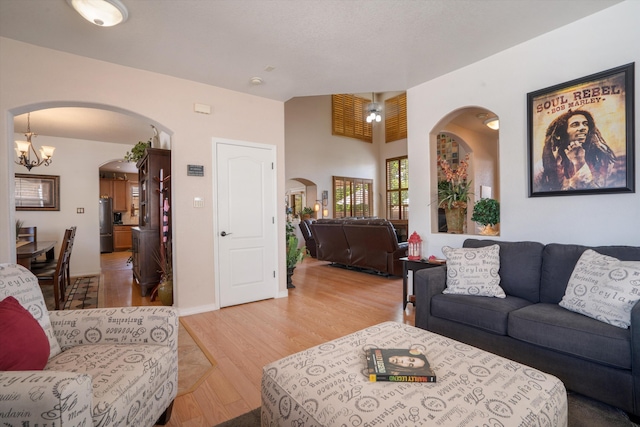 1417 Montiano Loop SE, Rio Rancho, NM 87124 - living area featuring arched walkways, light wood-style floors, and a chandelier
