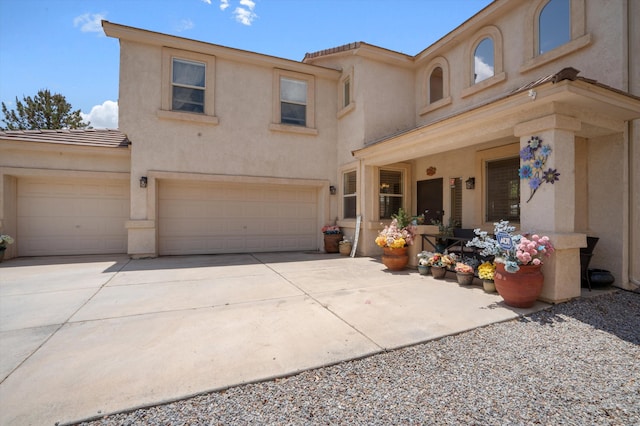 1417 Montiano Loop SE, Rio Rancho, NM 87124 - view of front of home featuring driveway, stucco siding, a tiled roof, and an attached garage