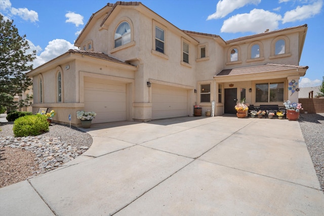 1417 Montiano Loop SE, Rio Rancho, NM 87124 - mediterranean / spanish house featuring an attached garage, stucco siding, a tiled roof, and driveway