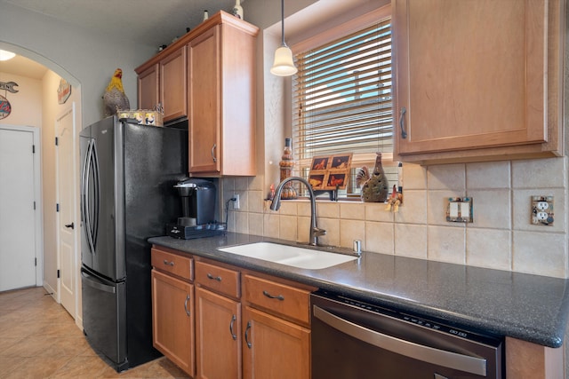 1417 Montiano Loop SE, Rio Rancho, NM 87124 - kitchen featuring dishwasher, freestanding refrigerator, dark countertops, backsplash, and brown cabinets