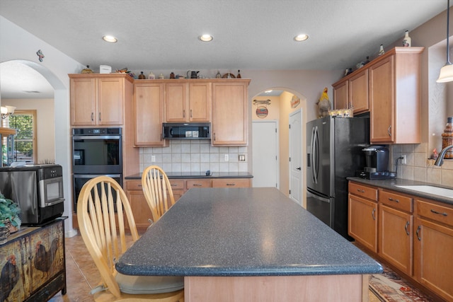 1417 Montiano Loop SE, Rio Rancho, NM 87124 - kitchen with black appliances, arched walkways, dark countertops, a kitchen island, and backsplash