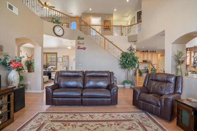 1417 Montiano Loop SE, Rio Rancho, NM 87124 - living area featuring light wood-style floors, a towering ceiling, stairs, arched walkways, and recessed lighting