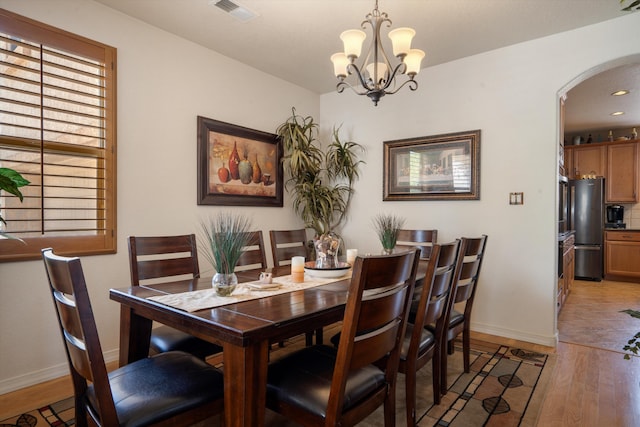 1417 Montiano Loop SE, Rio Rancho, NM 87124 - dining room featuring arched walkways, light wood-style floors, and a chandelier
