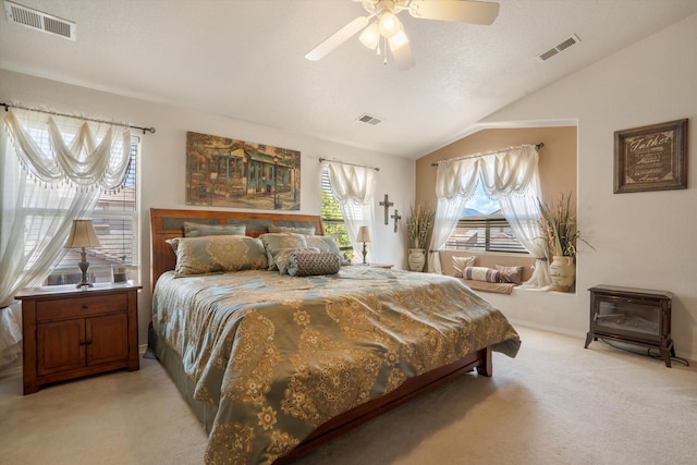 1417 Montiano Loop SE, Rio Rancho, NM 87124 - bedroom featuring vaulted ceiling, light carpet, a wood stove, and a ceiling fan