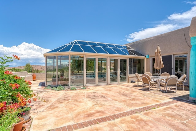 15 Sunset Blvd, Placitas, NM 87043 - back of property featuring a patio, a sunroom, stucco siding, and outdoor dining space