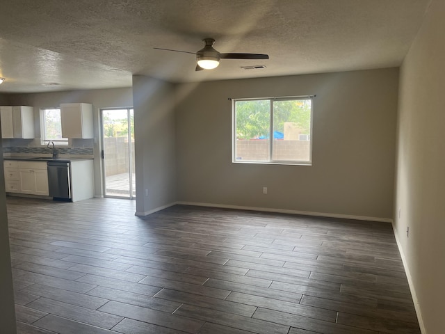 3005 Quail Point Dr, Albuquerque, NM 87120 - unfurnished living room with a textured ceiling, plenty of natural light, ceiling fan, and dark wood-style flooring