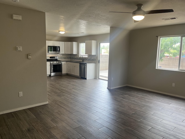 3005 Quail Point Dr, Albuquerque, NM 87120 - kitchen with stainless steel appliances, ceiling fan, dark wood-style flooring, white cabinetry, and a textured ceiling
