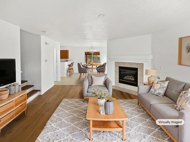 5355 Feather Rock Pl NW, Albuquerque, NM 87114 - living area featuring wood finished floors, a chandelier, and a tiled fireplace