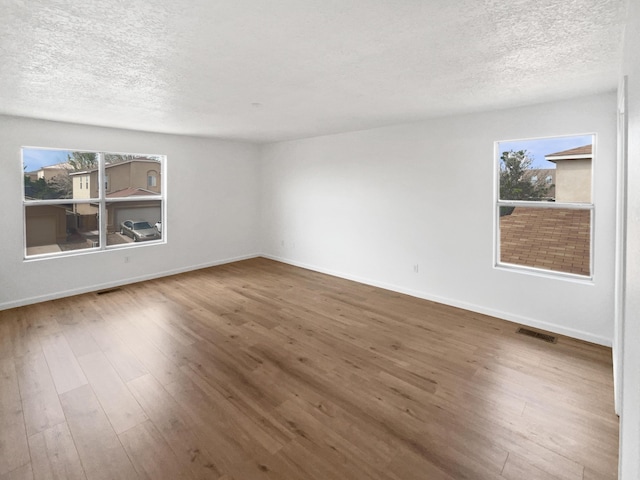 5355 Feather Rock Pl NW, Albuquerque, NM 87114 - empty room with a textured ceiling, healthy amount of natural light, and wood finished floors