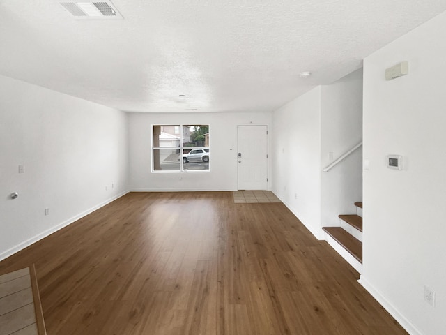 5355 Feather Rock Pl NW, Albuquerque, NM 87114 - unfurnished living room featuring stairs, wood finished floors, and a textured ceiling