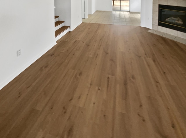 5355 Feather Rock Pl NW, Albuquerque, NM 87114 - unfurnished living room featuring wood finished floors, stairway, and a fireplace