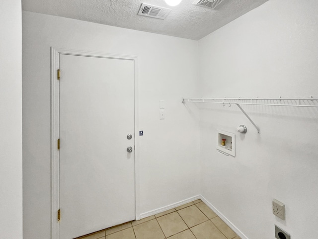 5355 Feather Rock Pl NW, Albuquerque, NM 87114 - washroom featuring a textured ceiling, light tile patterned flooring, and washer hookup