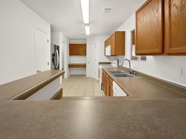 5355 Feather Rock Pl NW, Albuquerque, NM 87114 - kitchen featuring white appliances, brown cabinetry, and light tile patterned floors