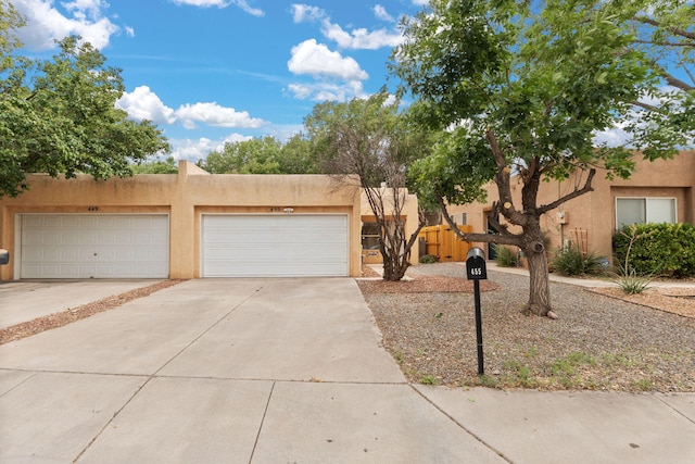 455 Colonial Ave SW, Los Lunas, NM 87031 - adobe home with stucco siding, concrete driveway, and a garage