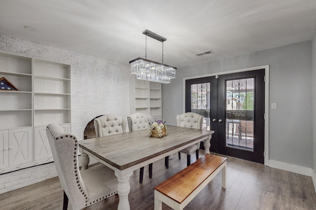 4320 Blumenshine Cir SW, Albuquerque, NM 87105 - dining space featuring a chandelier, built in shelves, wood finished floors, and french doors