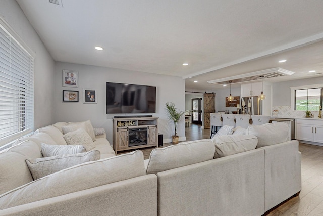 4320 Blumenshine Cir SW, Albuquerque, NM 87105 - living room with a barn door, light wood-type flooring, and recessed lighting