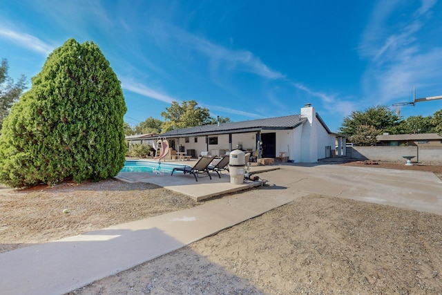 4320 Blumenshine Cir SW, Albuquerque, NM 87105 - back of property featuring a chimney, a patio area, an outdoor pool, and stucco siding