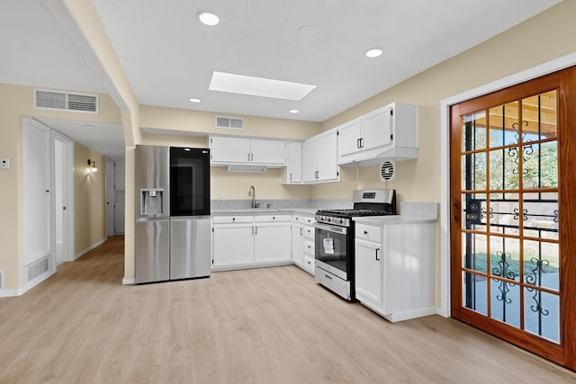 10409 Britt Ct NE, Albuquerque, NM 87112 - kitchen with stainless steel appliances, a skylight, light wood-type flooring, light countertops, and recessed lighting