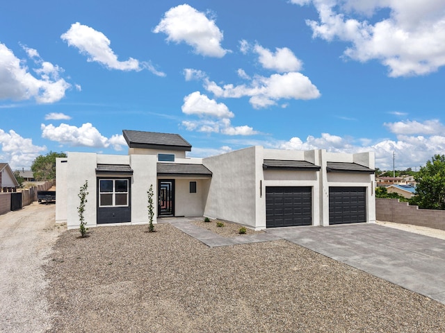 1109 11th St SE, Rio Rancho, NM 87124 - contemporary house featuring an attached garage, concrete driveway, and stucco siding
