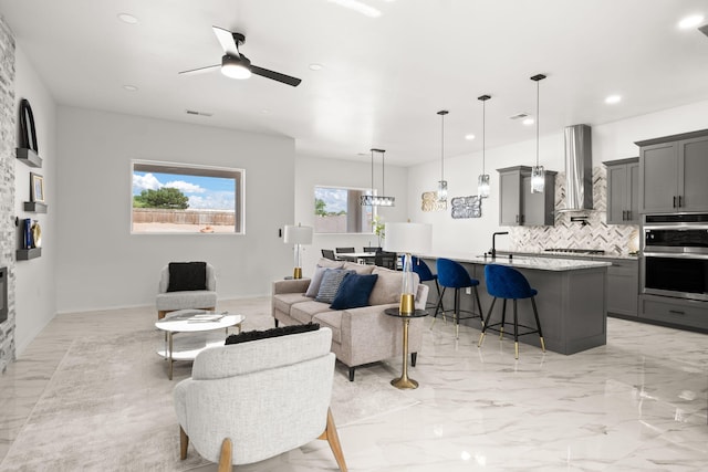 1109 11th St SE, Rio Rancho, NM 87124 - living room featuring a ceiling fan, recessed lighting, and light marble finish floors