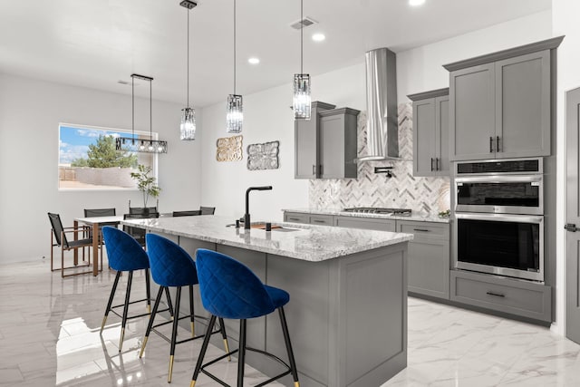 1109 11th St SE, Rio Rancho, NM 87124 - kitchen with gray cabinets, stainless steel appliances, wall chimney range hood, light marble finish floors, and light stone countertops