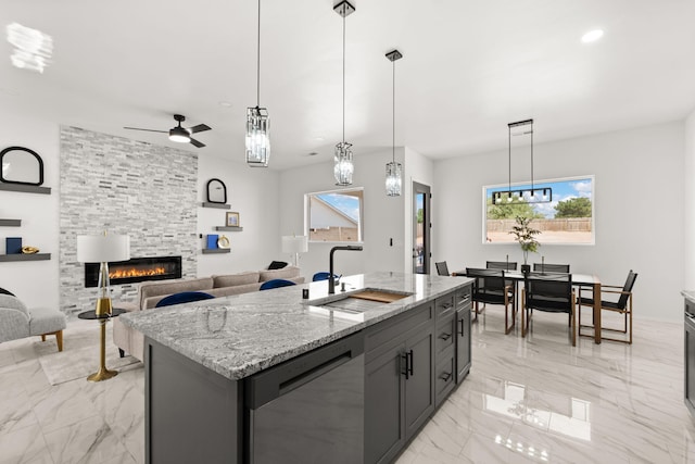 1109 11th St SE, Rio Rancho, NM 87124 - kitchen featuring stainless steel dishwasher, a fireplace, light marble finish floors, ceiling fan, and light stone countertops