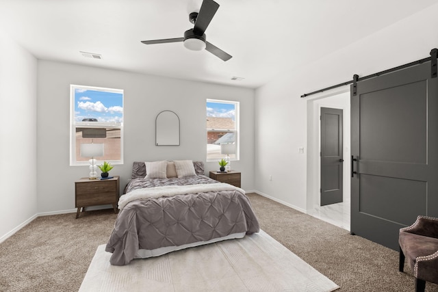 1109 11th St SE, Rio Rancho, NM 87124 - bedroom with a barn door, light carpet, and ceiling fan