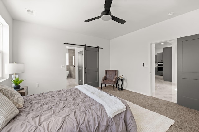 1109 11th St SE, Rio Rancho, NM 87124 - bedroom featuring a barn door, light colored carpet, ensuite bath, and ceiling fan