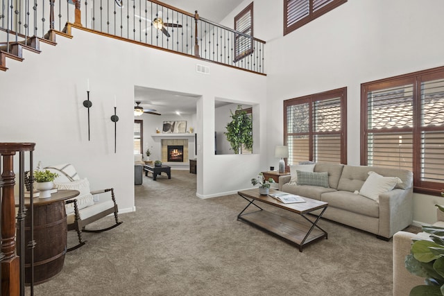 44 Los Balcones Pl NE, Rio Rancho, NM 87124 - living area with a ceiling fan, carpet flooring, a high ceiling, a tiled fireplace, and stairway