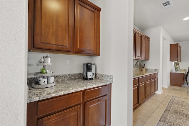 44 Los Balcones Pl NE, Rio Rancho, NM 87124 - kitchen featuring light tile patterned flooring, light stone counters, and brown cabinetry