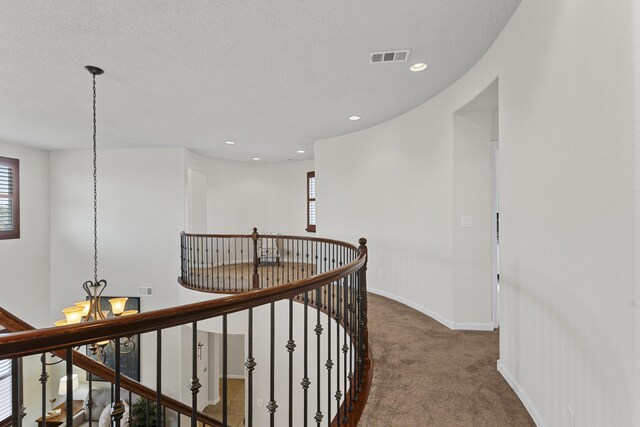 44 Los Balcones Pl NE, Rio Rancho, NM 87124 - hallway featuring a chandelier, carpet flooring, an upstairs landing, and recessed lighting