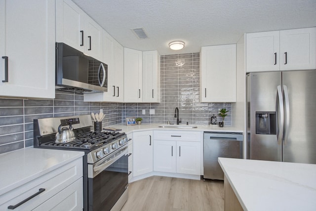 4920 Black Dr NW, Albuquerque, NM 87120 - kitchen featuring stainless steel appliances, light countertops, light wood finished floors, and a textured ceiling