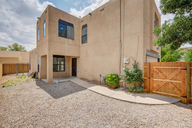 4920 Black Dr NW, Albuquerque, NM 87120 - rear view of house with a gate, stucco siding, and a patio area