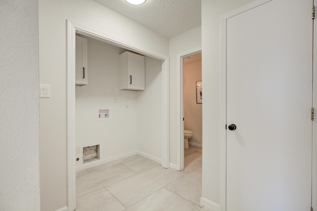 4920 Black Dr NW, Albuquerque, NM 87120 - laundry area with cabinet space, hookup for a washing machine, a textured ceiling, and light tile patterned floors