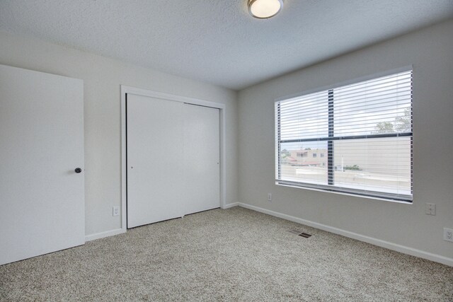 4920 Black Dr NW, Albuquerque, NM 87120 - unfurnished bedroom with carpet flooring, a closet, and a textured ceiling