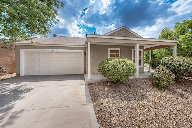 10639 Miera Dr NW, Albuquerque, NM 87114 - view of front of home featuring an attached garage, driveway, stucco siding, and a porch