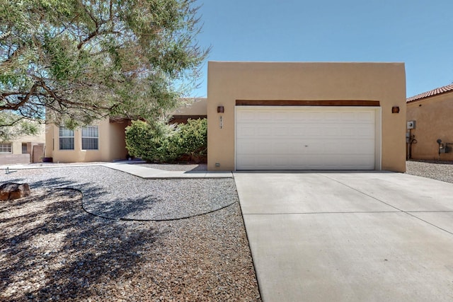 8712 Sandwater Rd NW, Albuquerque, NM 87120 - pueblo revival-style home featuring stucco siding, concrete driveway, and a garage