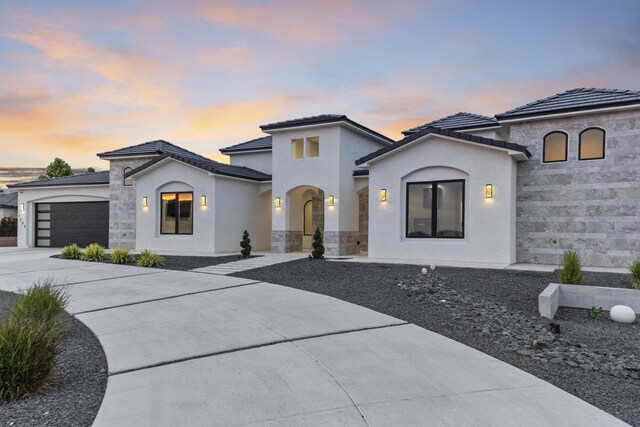 7900 Aguila St NW, Albuquerque, NM 87120 - view of front of home featuring a garage, concrete driveway, stone siding, stucco siding, and a tile roof