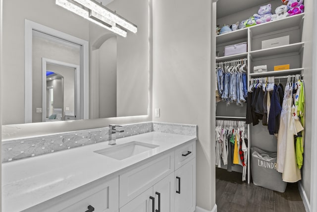 7900 Aguila St NW, Albuquerque, NM 87120 - bathroom with vanity, wood finished floors, and a spacious closet