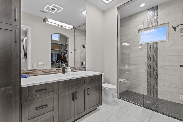 7900 Aguila St NW, Albuquerque, NM 87120 - bathroom with vanity, a stall shower, a spacious closet, tasteful backsplash, and recessed lighting