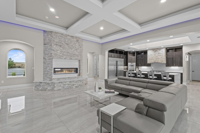 7900 Aguila St NW, Albuquerque, NM 87120 - living area with arched walkways, coffered ceiling, a stone fireplace, beam ceiling, and recessed lighting