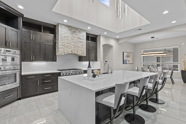 7900 Aguila St NW, Albuquerque, NM 87120 - kitchen with appliances with stainless steel finishes, recessed lighting, light countertops, a kitchen breakfast bar, and a kitchen island with sink