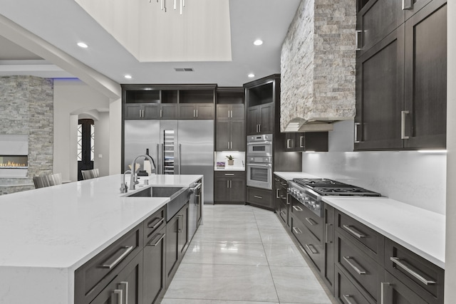 7900 Aguila St NW, Albuquerque, NM 87120 - kitchen featuring stainless steel appliances, recessed lighting, a large island, light marble finish flooring, and a stone fireplace