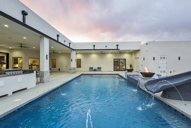 7900 Aguila St NW, Albuquerque, NM 87120 - view of swimming pool featuring ceiling fan, a water slide, an outdoor kitchen, and a pool