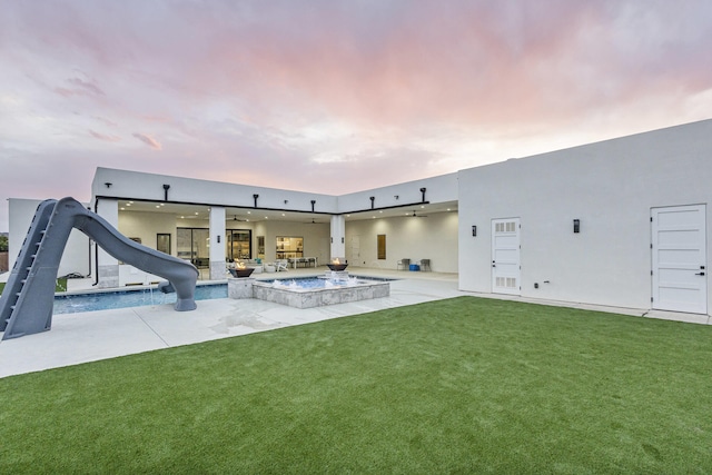 7900 Aguila St NW, Albuquerque, NM 87120 - back of house with ceiling fan, a patio area, a yard, an outdoor pool, and stucco siding