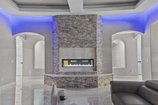 7900 Aguila St NW, Albuquerque, NM 87120 - living area with a glass covered fireplace, arched walkways, a tray ceiling, and tile patterned flooring