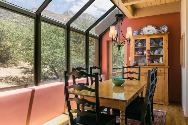 213 Spring Creek Pl NE, Albuquerque, NM 87122 - dining area with healthy amount of natural light, wood finished floors, a sunroom, and beam ceiling