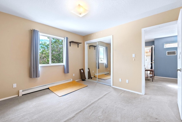6412 Saint Josephs Ave NW, Albuquerque, NM 87120 - unfurnished bedroom with a baseboard heating unit, carpet, and a closet