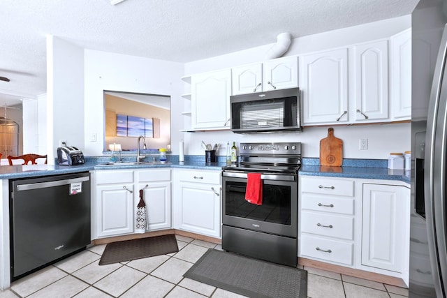 6412 Saint Josephs Ave NW, Albuquerque, NM 87120 - kitchen featuring appliances with stainless steel finishes, light tile patterned flooring, white cabinets, dark countertops, and open shelves